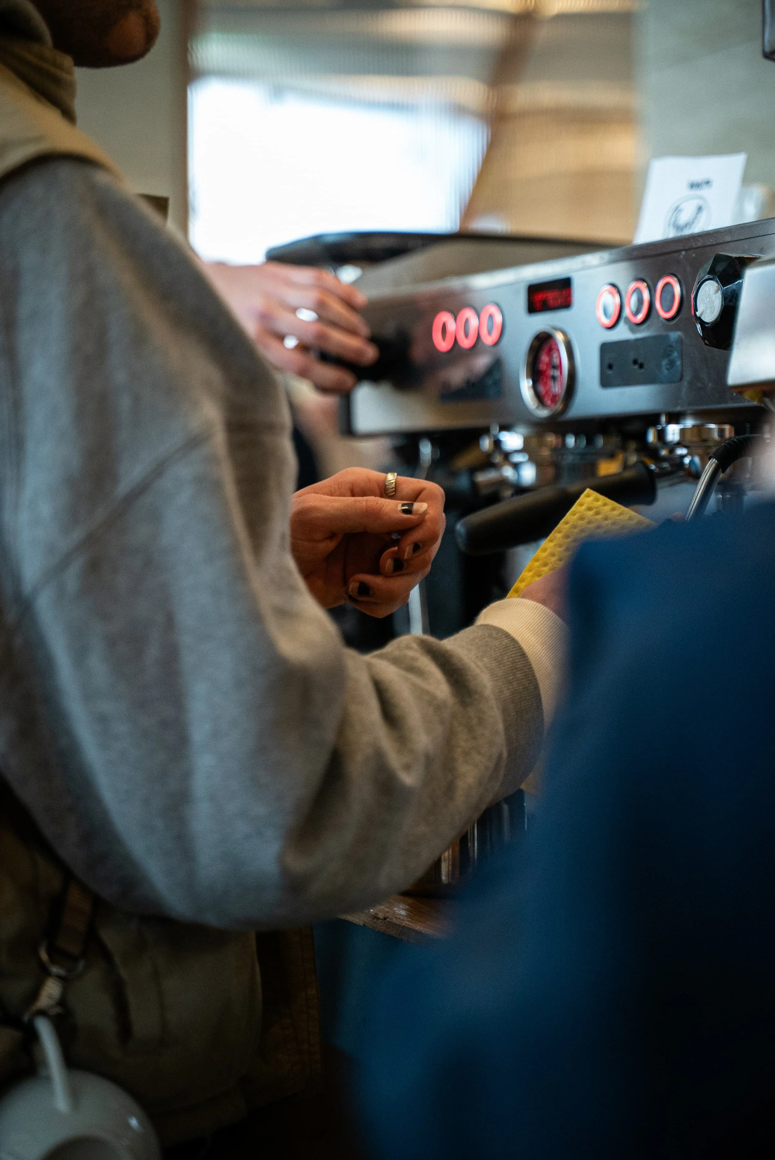 Personne utilisant une machine à expresso dans un café ou une cuisine.