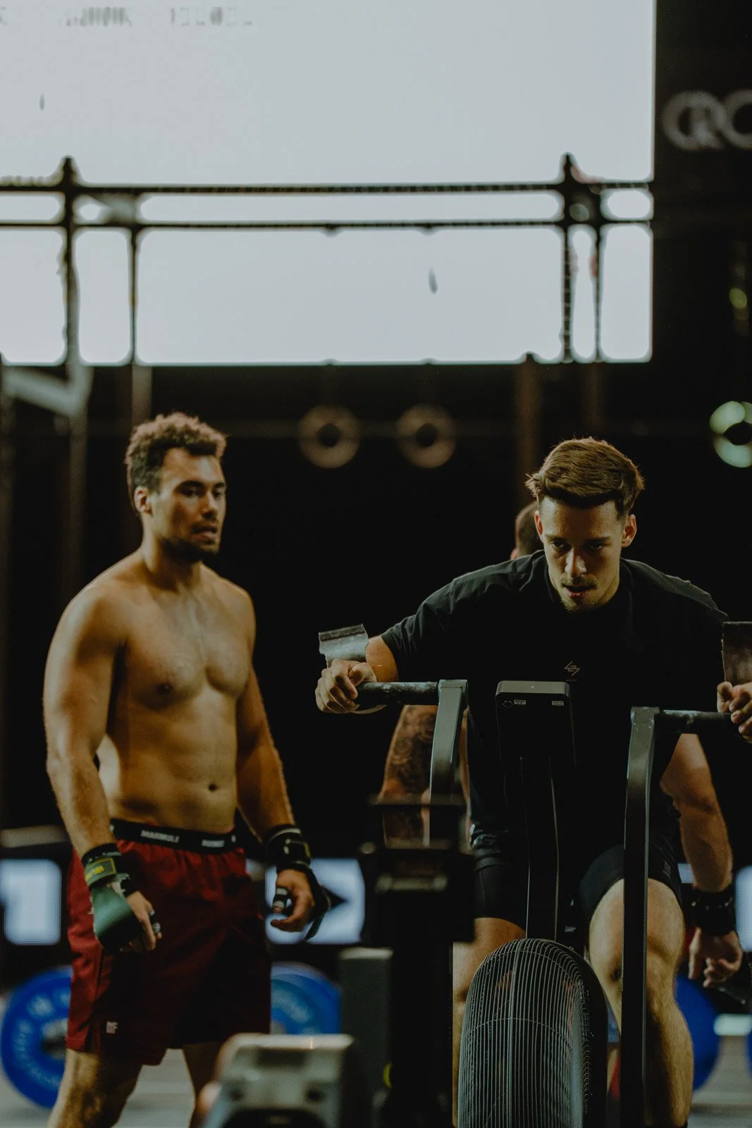 Deux hommes s'entraînant dans une salle CrossFit avec vélo d'appartement à Bordeaux — photographe CrossFit Voar by Tim