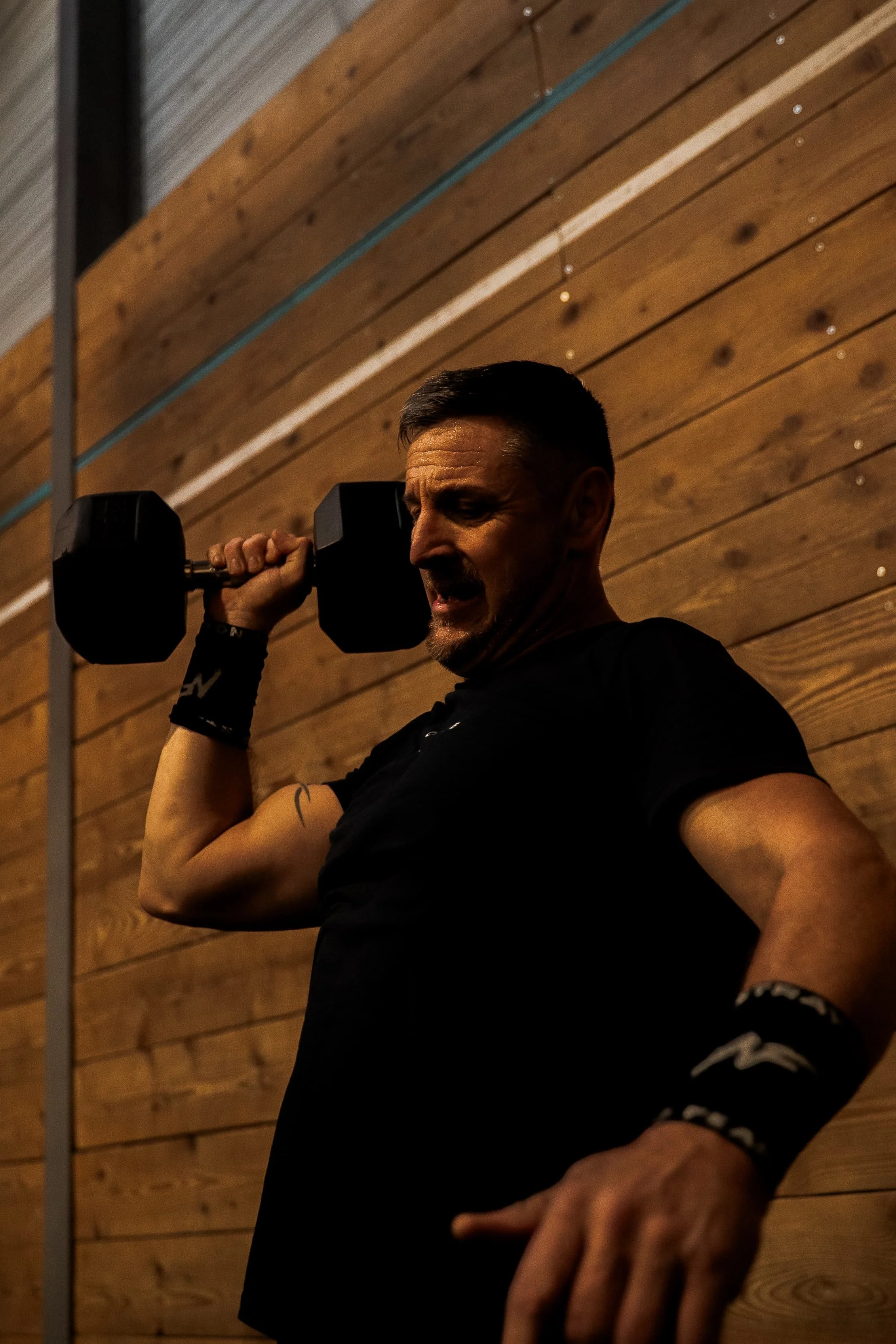 Un homme en train de faire de l'exercice avec un haltère dans une salle de sport.