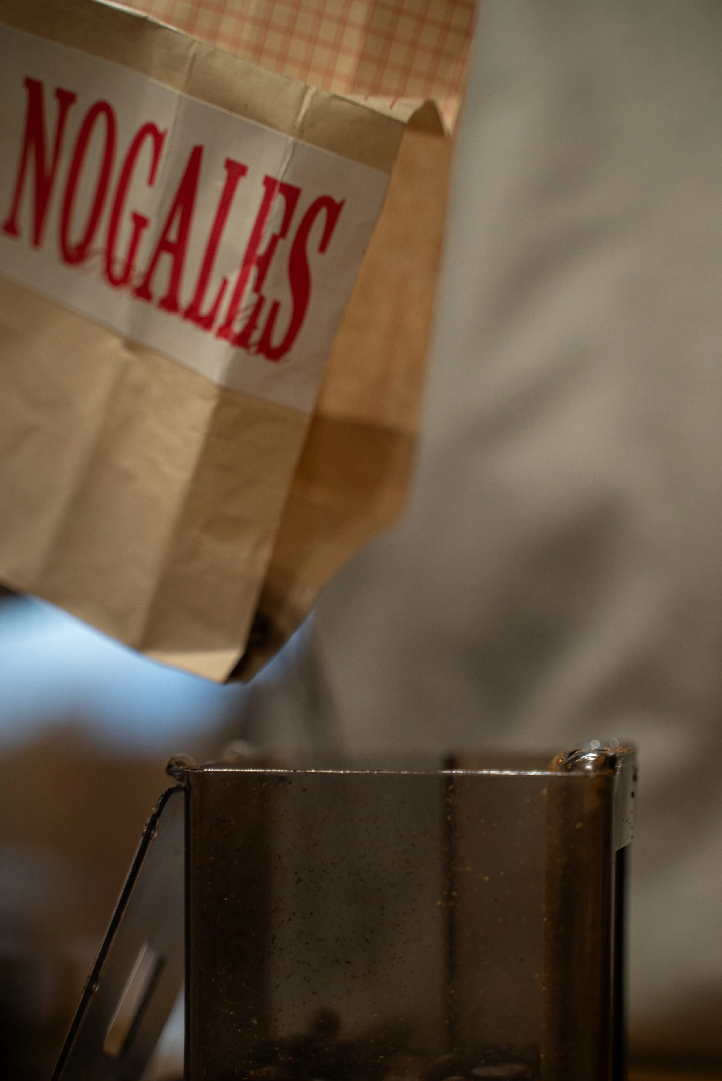 Une boîte en carton avec le mot 'NOUAILLES' en lettres rouges, placée sur une surface en bois, à côté d’un grille-pain en métal.