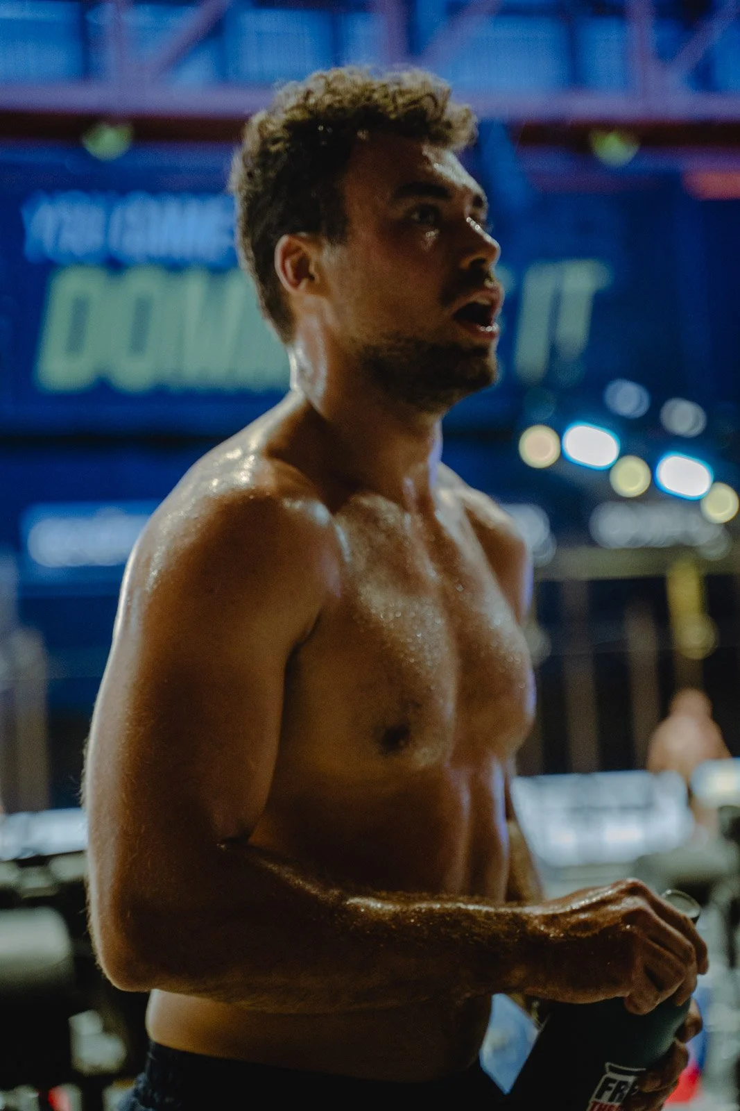 Homme torse nu trempé de sueur sous éclairages colorés lors d'un événement CrossFit à Bordeaux — photographe CrossFit Voar by Tim