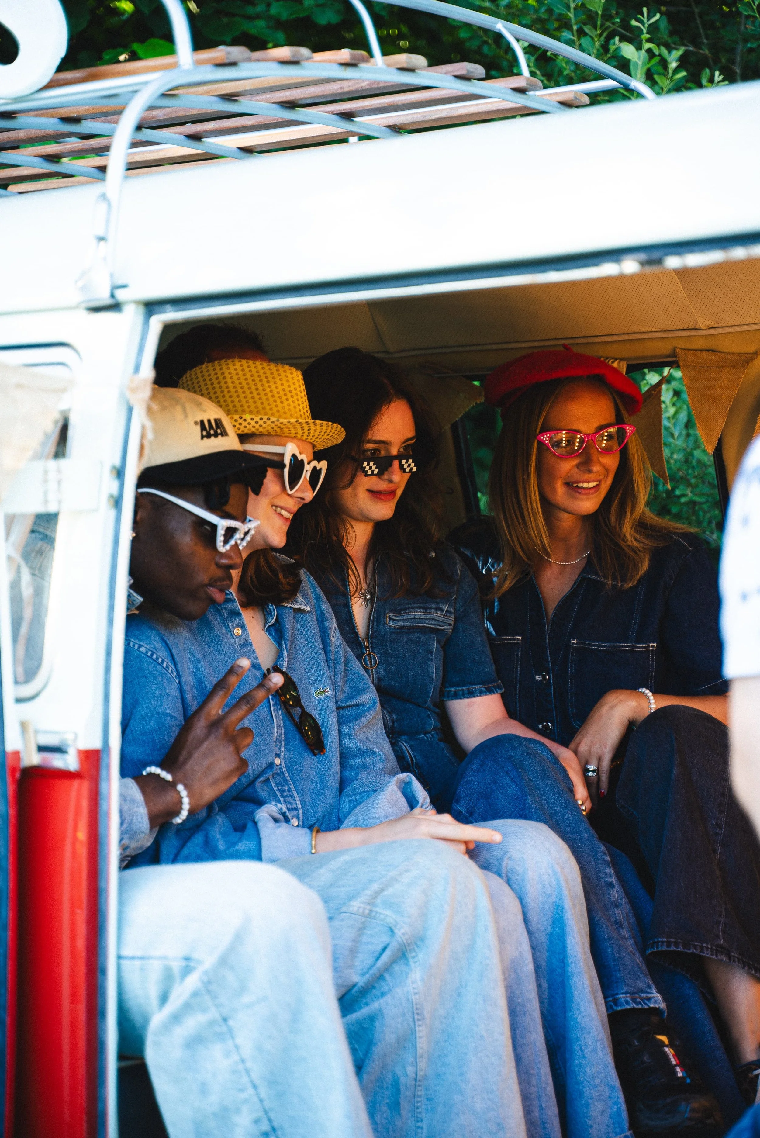Groupe de jeunes femmes assises dans une calèche en plein air, portant des accessoires colorés et des vêtements en jean, discutant et riant.