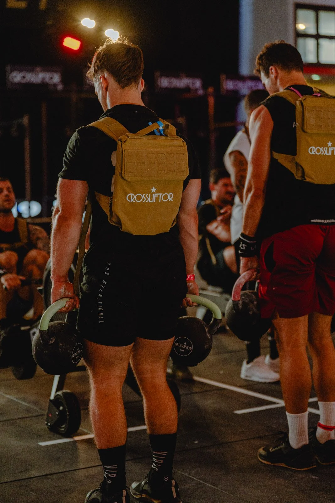 Jeunes hommes participant à un entraînement CrossFit nocturne avec sacs à dos en Nouvelle-Aquitaine — photographe CrossFit Voar by Tim