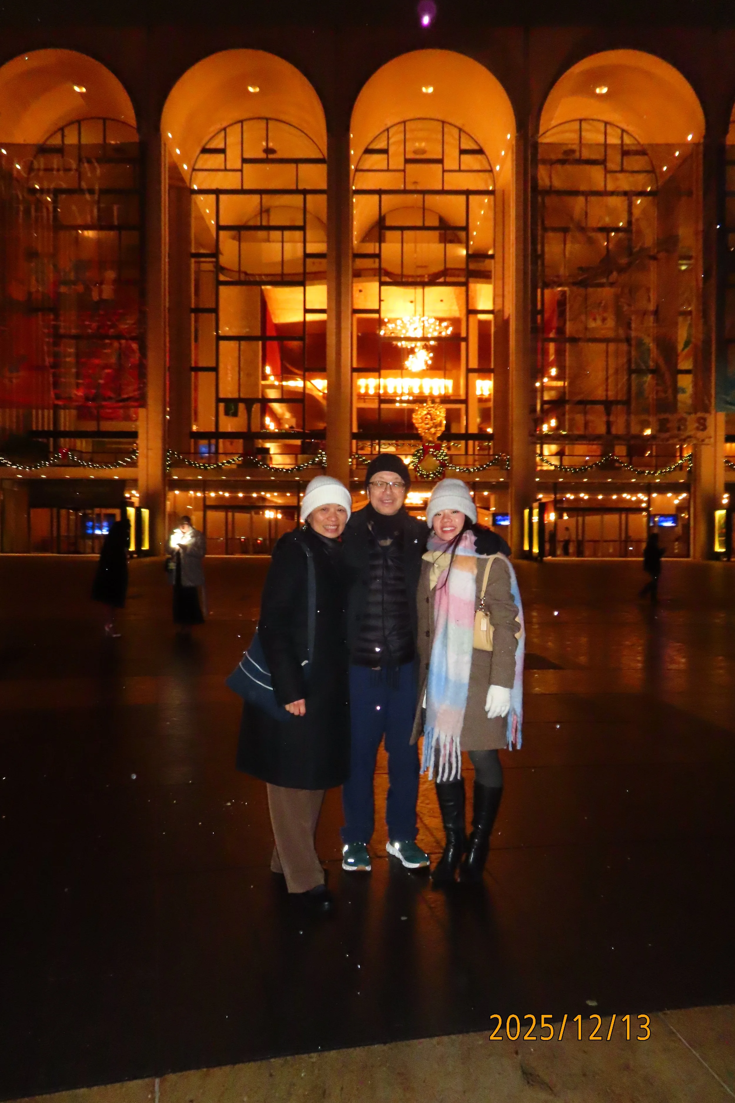 Three women standing together outside a building decorated for Christmas, with the date 2025/12/13 visible at the bottom.