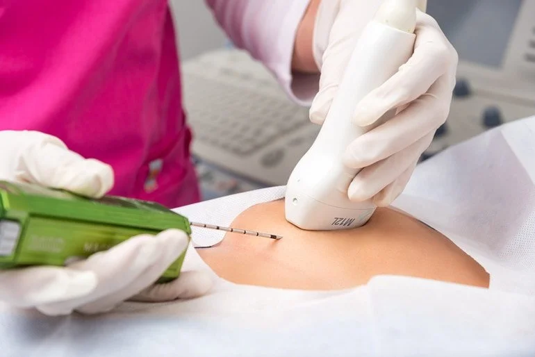 Paciente recibe una inyección con una jeringa en un brazo en un entorno médico.