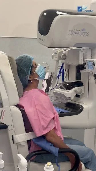 Médico en equipo de protección realiza un examen en una máquina de diagnóstico médico en un consultorio.