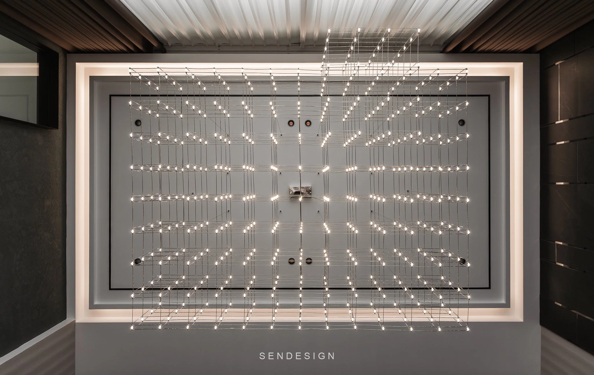 Modern lighting fixture with numerous small lights forming geometric patterns in a gray room with white ceiling and black trim