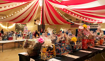Silent auction items displayed at an “Under the Big Top” themed fundraising event.
