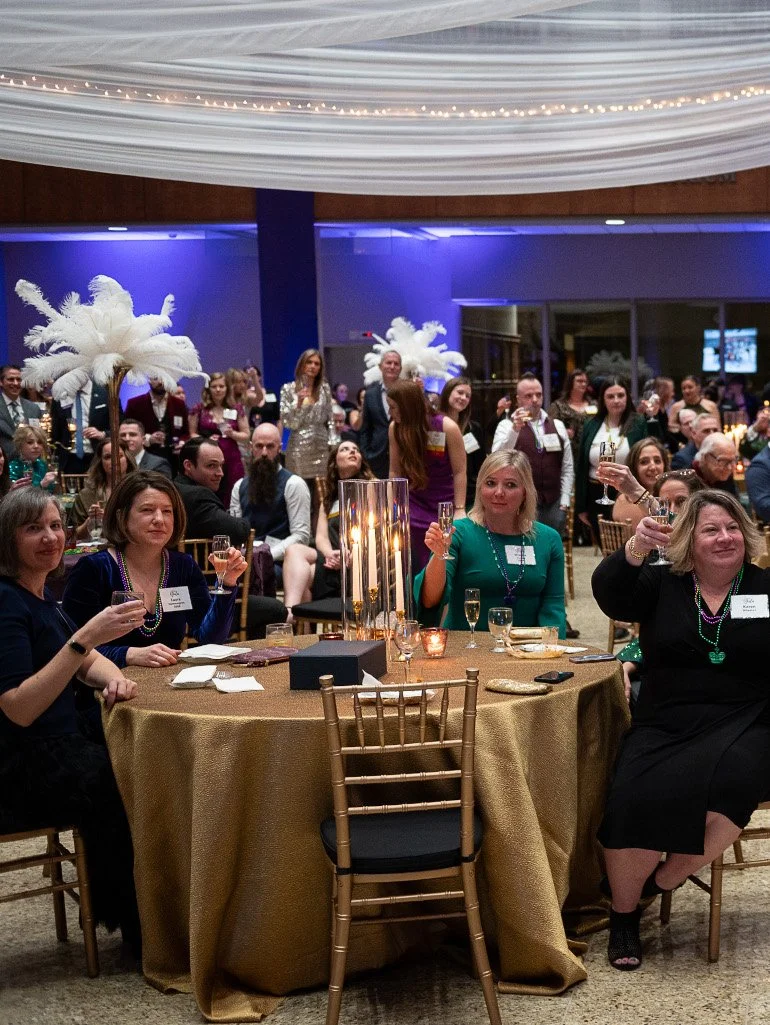 Guests participating in a live fundraising auction at a formal charity gala.