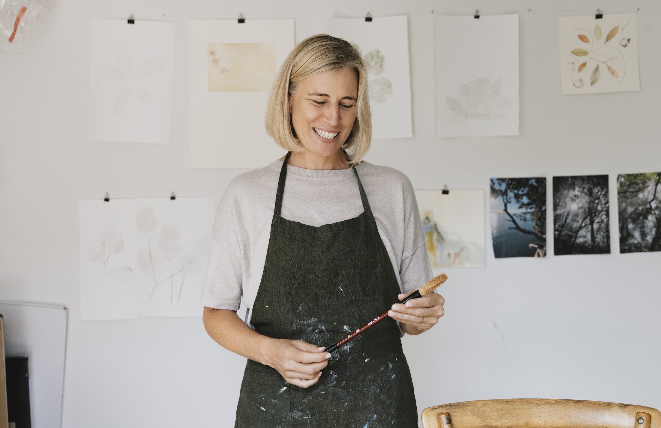 Nicky Scoltock, contemplative artist in Tāmaki Makaurau Auckland, in her studio with paintbrushes.