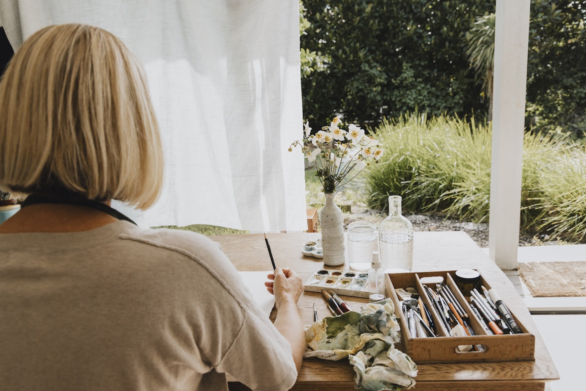Nicky Scoltock, contemplative artist, seated at her studio table in Auckland.