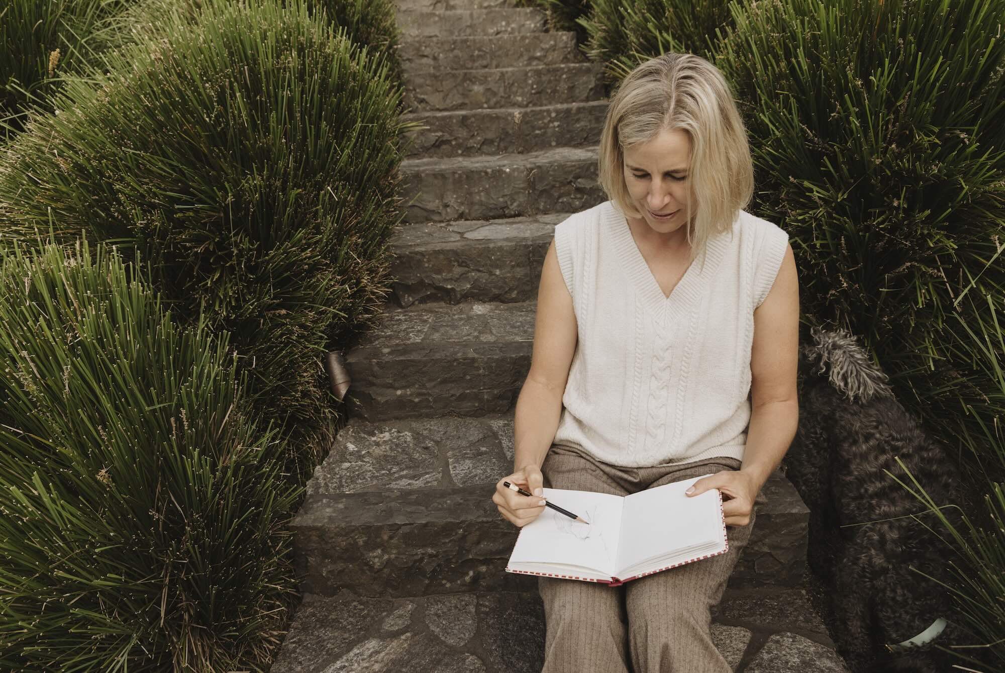 Nicky Scoltock sketching outdoors among native plants in Auckland.