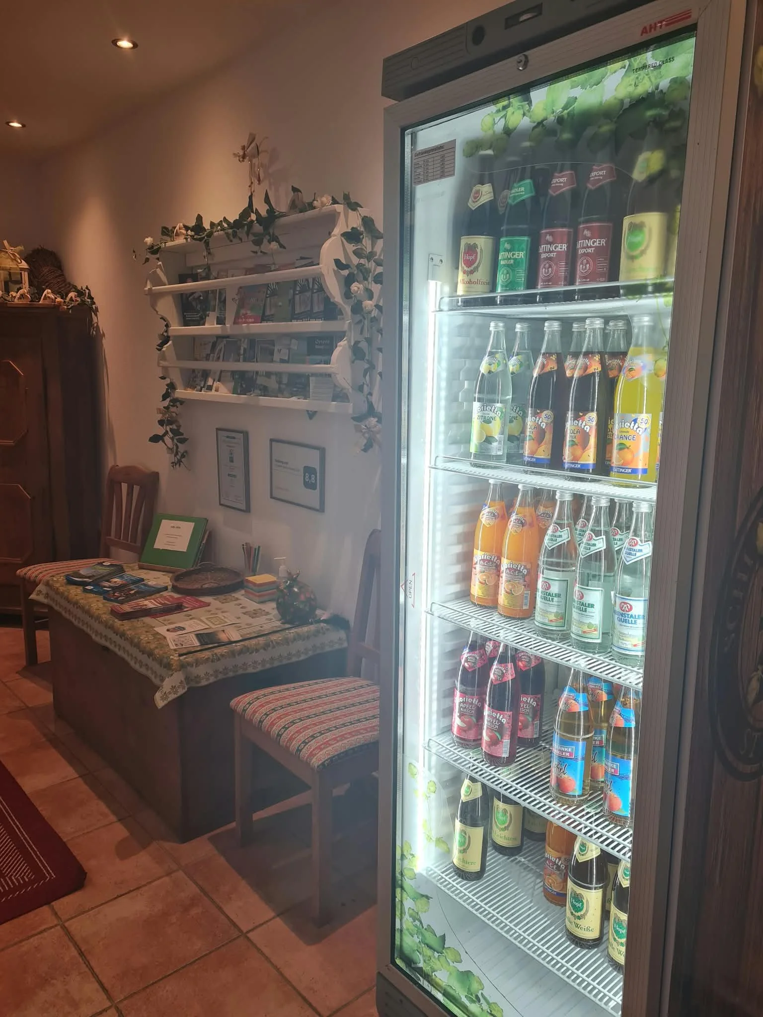 Getränkekühlschrank mit Bier, Limonaden und Mineralwasser in Gemeinschaftsraum.