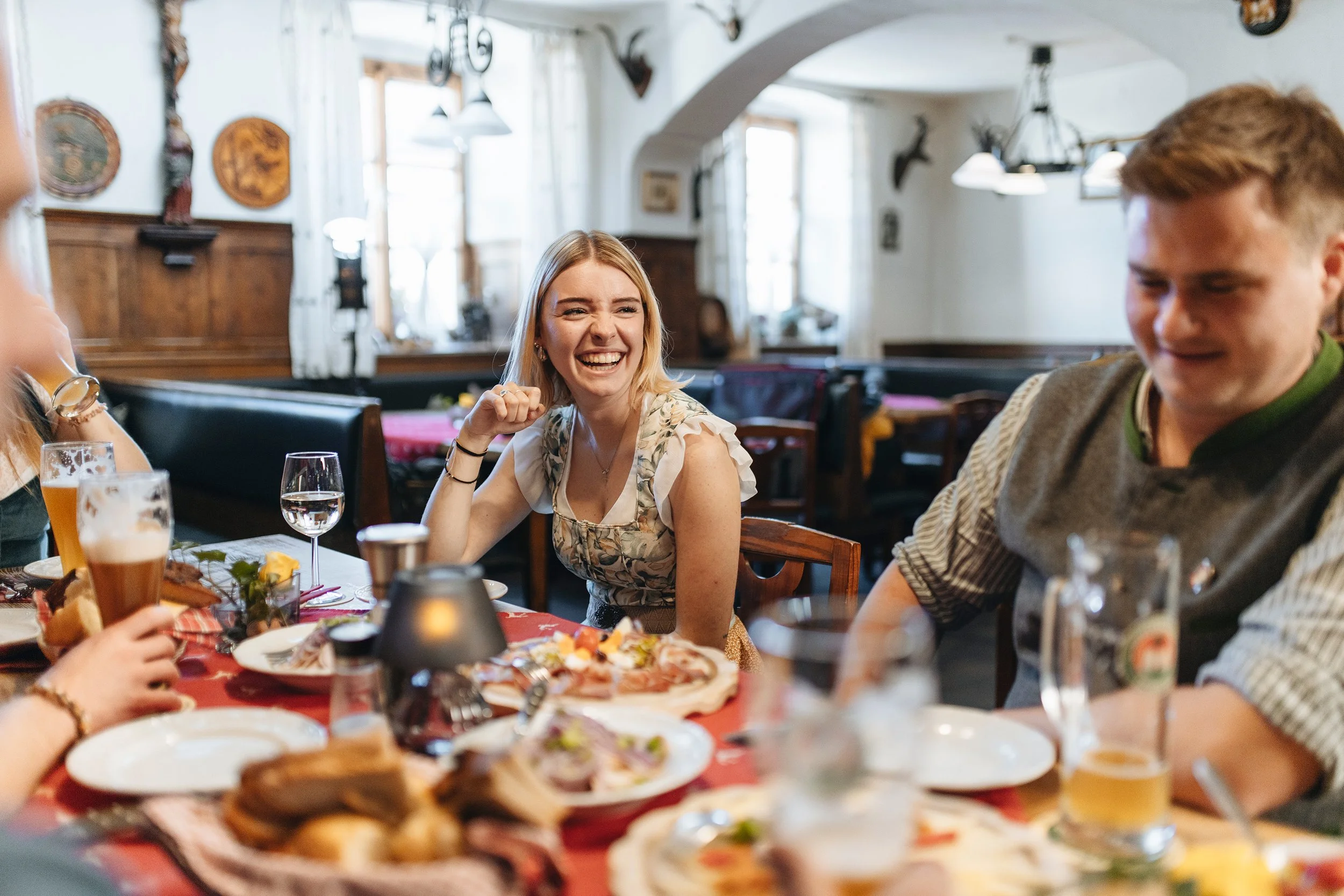 Menschen feiern zusammen bei einem Essen im Restaurant, lachen und haben Spaß.