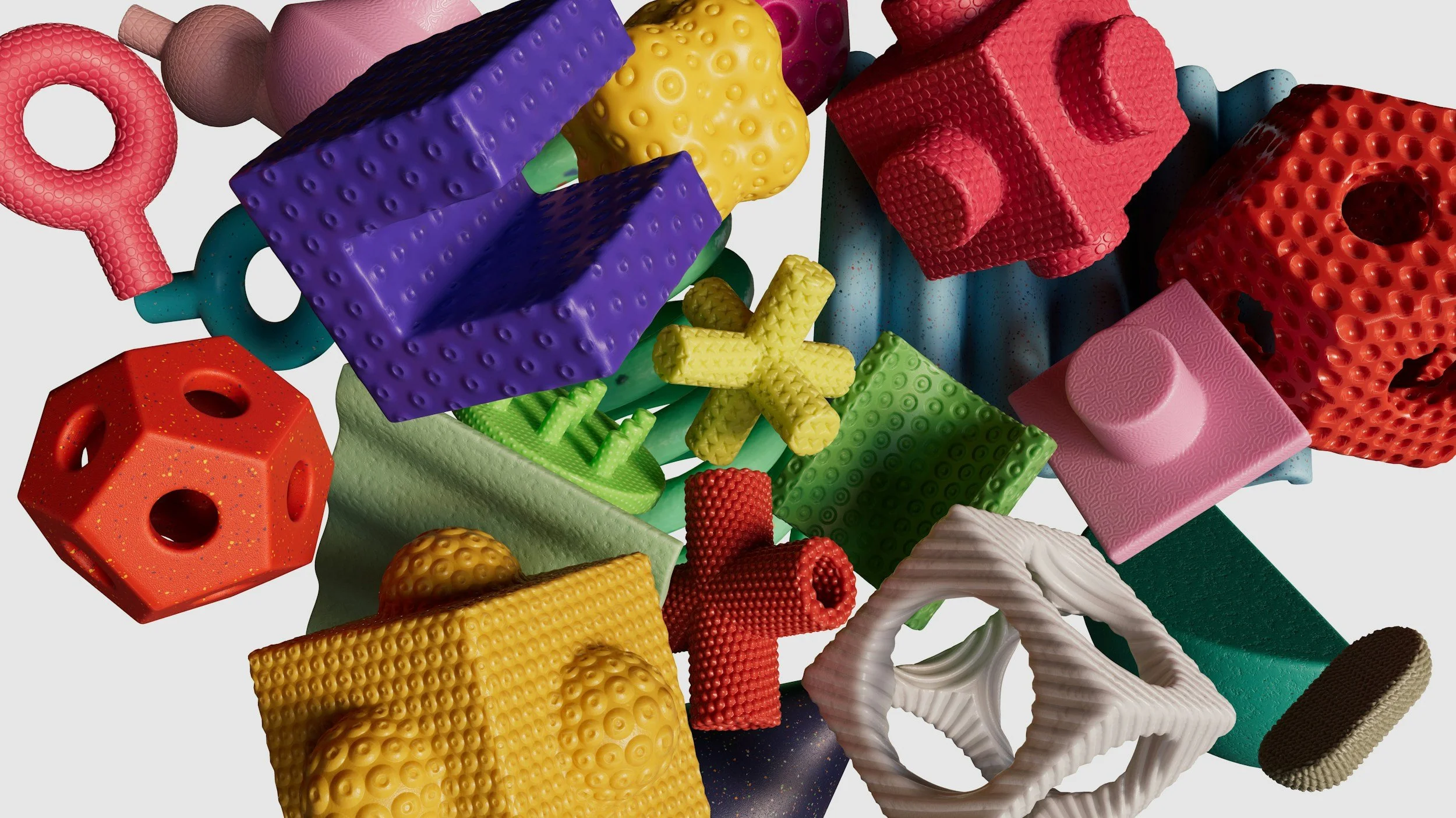 A collection of colorful, textured geometric toys and shapes. Includes balls, cubes, rings, and other abstract forms in various bright colors such as red, yellow, purple, green, pink, blue, and white with different surface patterns.