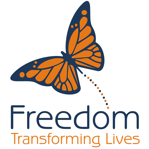 Illustration of a butterfly with orange and black wings and a dotted trail, with the words "Freedom" and "Transforming Lives" below.