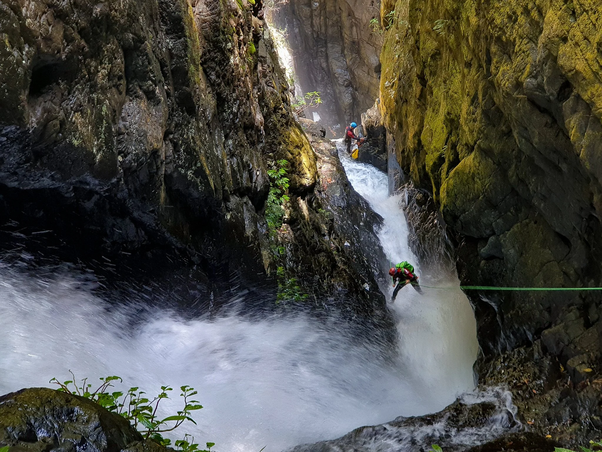 Abseiler beside a waterfall in Urumbilum Canyon