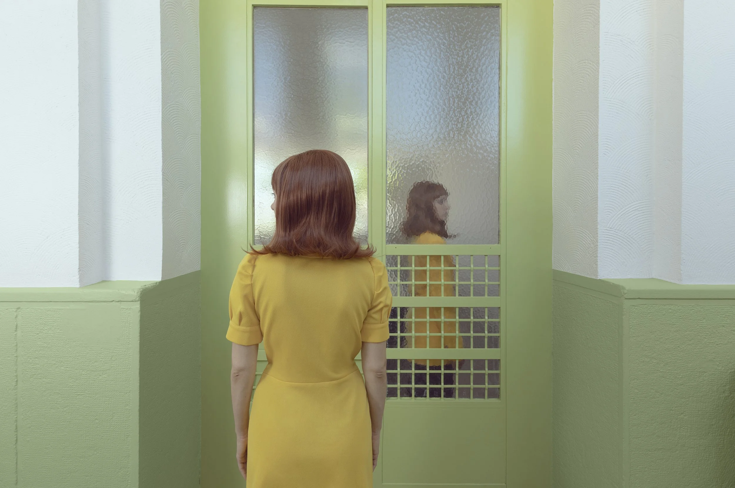 A woman with shoulder-length red hair in a yellow dress facing a frosted glass door with a small girl inside, visible through the textured glass.