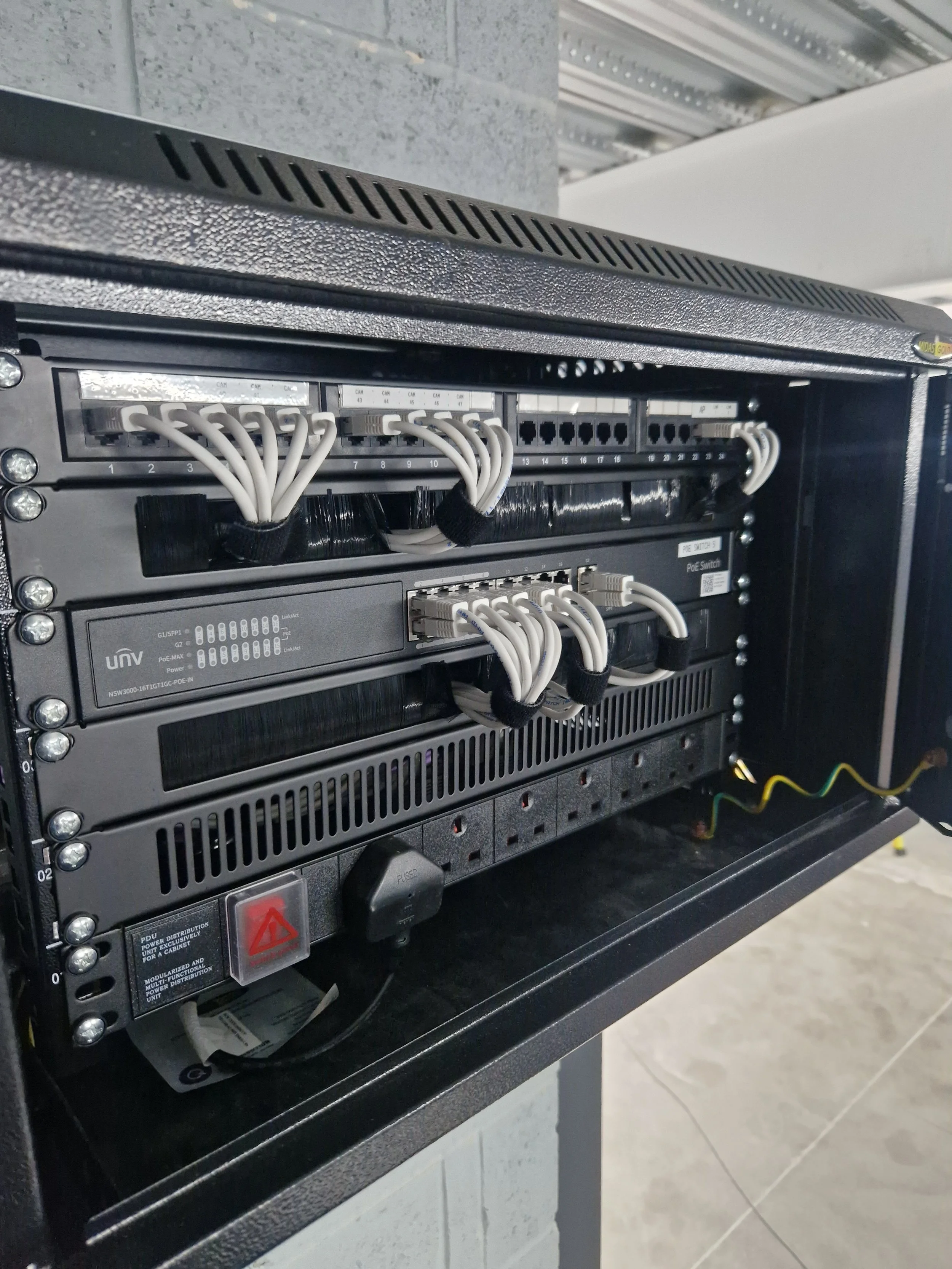 A server rack with multiple network switches and cables in a data center or server room.