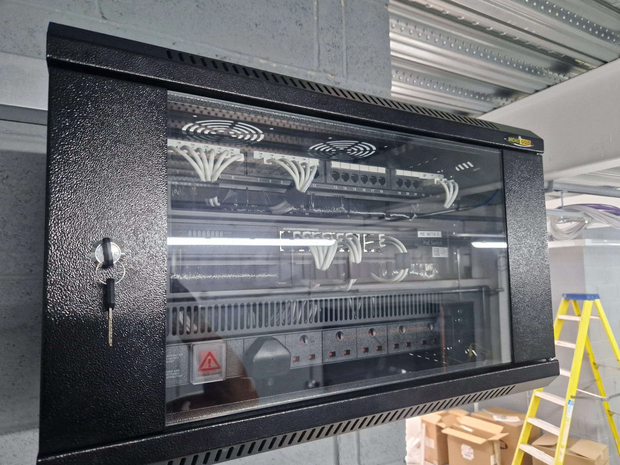 Close-up of an electrical switchgear or distribution panel with wiring, circuit breakers, and switches mounted inside a metal enclosure.