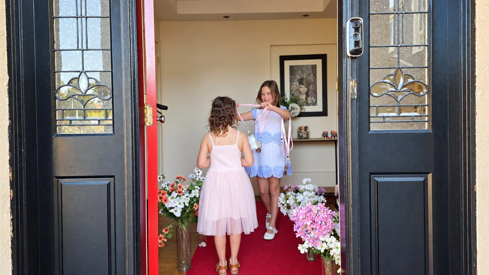 Two girls walking a red carpet through the front door to their VIP welcome at a Premiere Night party