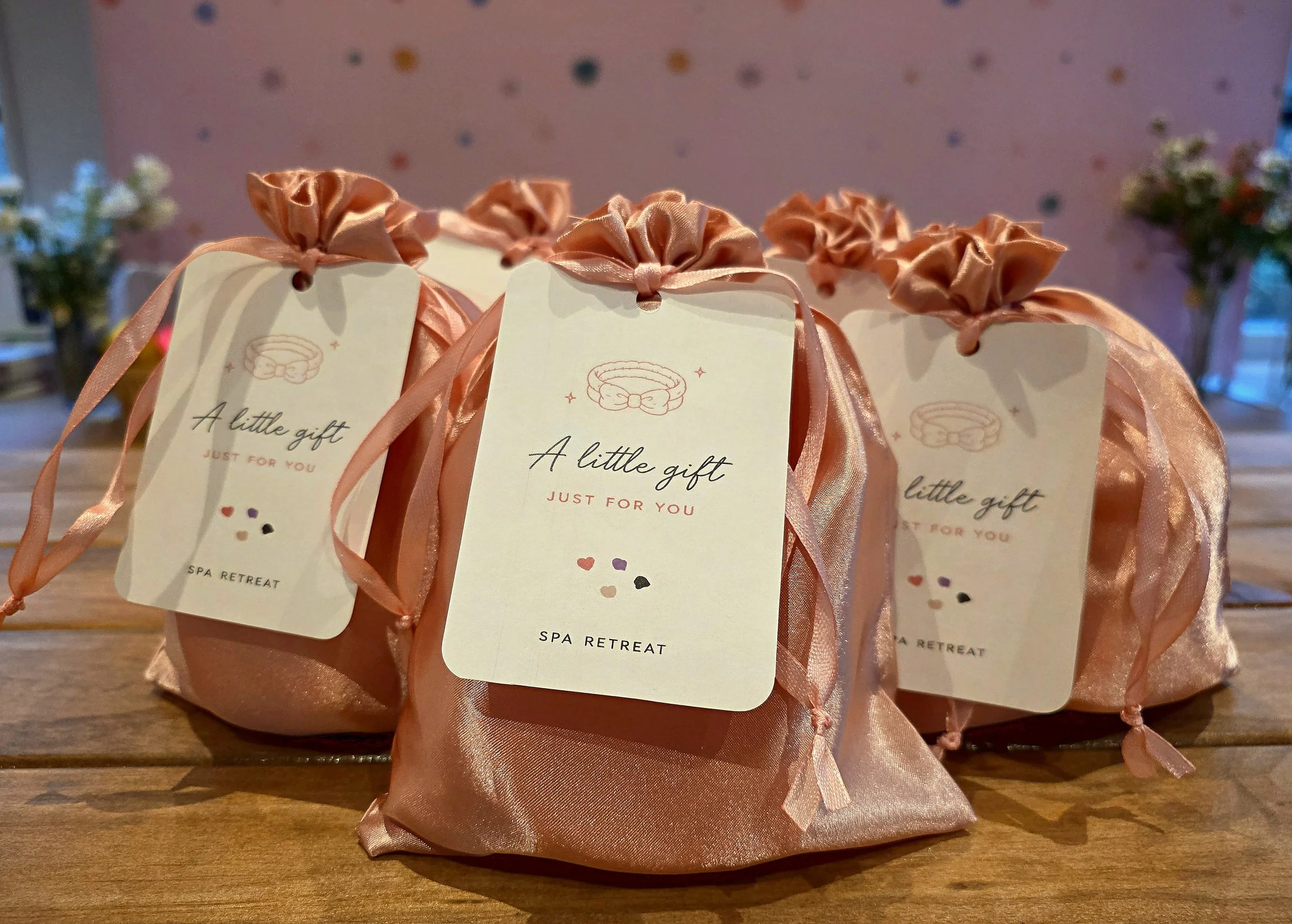 Satin spa party gift bags with 'A little gift just for you' tags