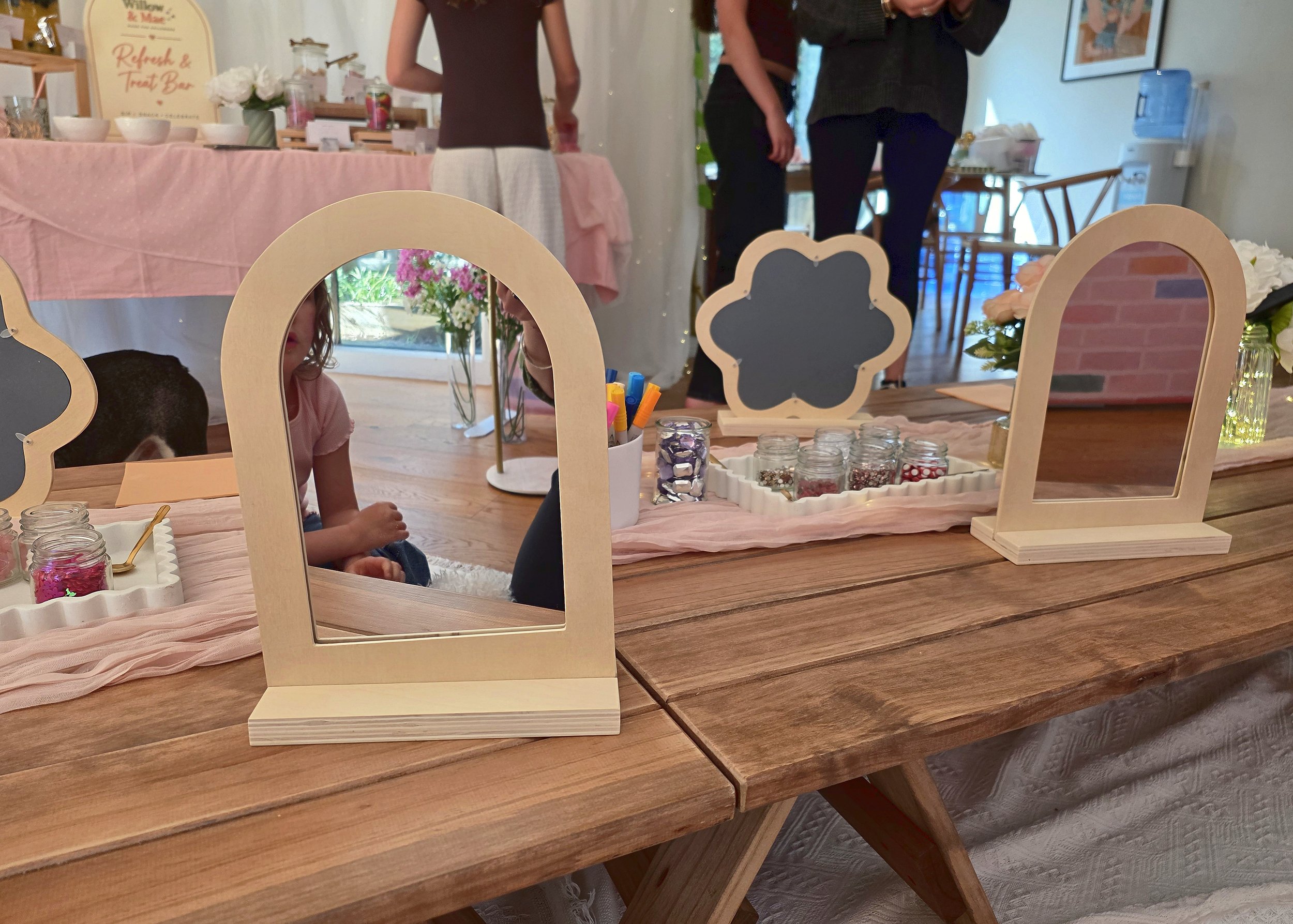 Blank wooden mirrors set out for decorating at a kids' craft party
