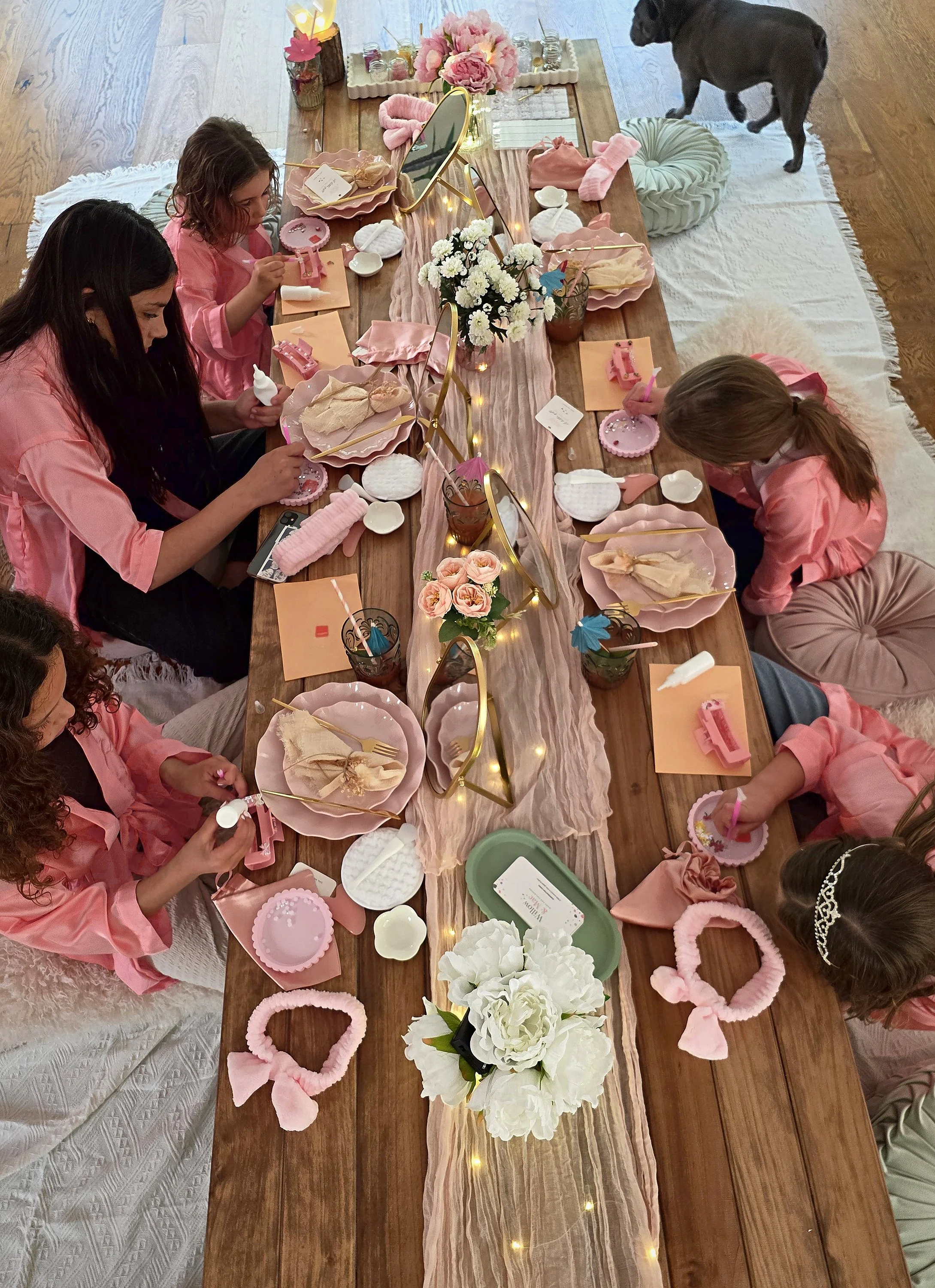 Overhead view of girls in pink robes around the spa party table