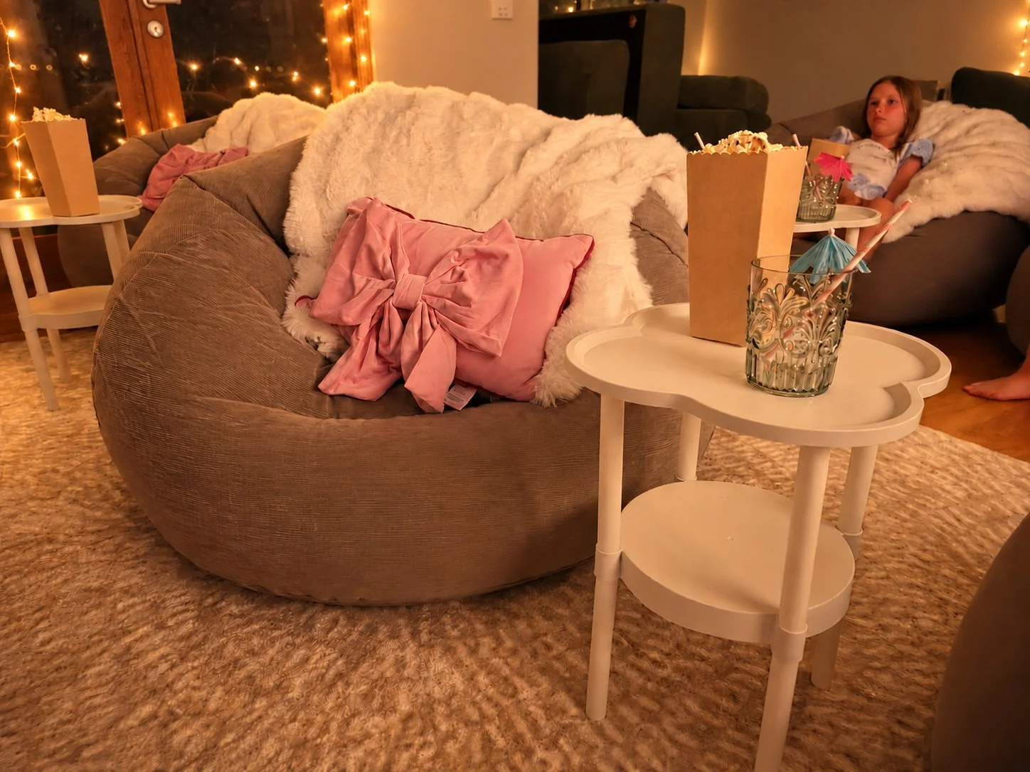 Movie night inflatable chair with a faux fur throw, popcorn box and drink on a side table