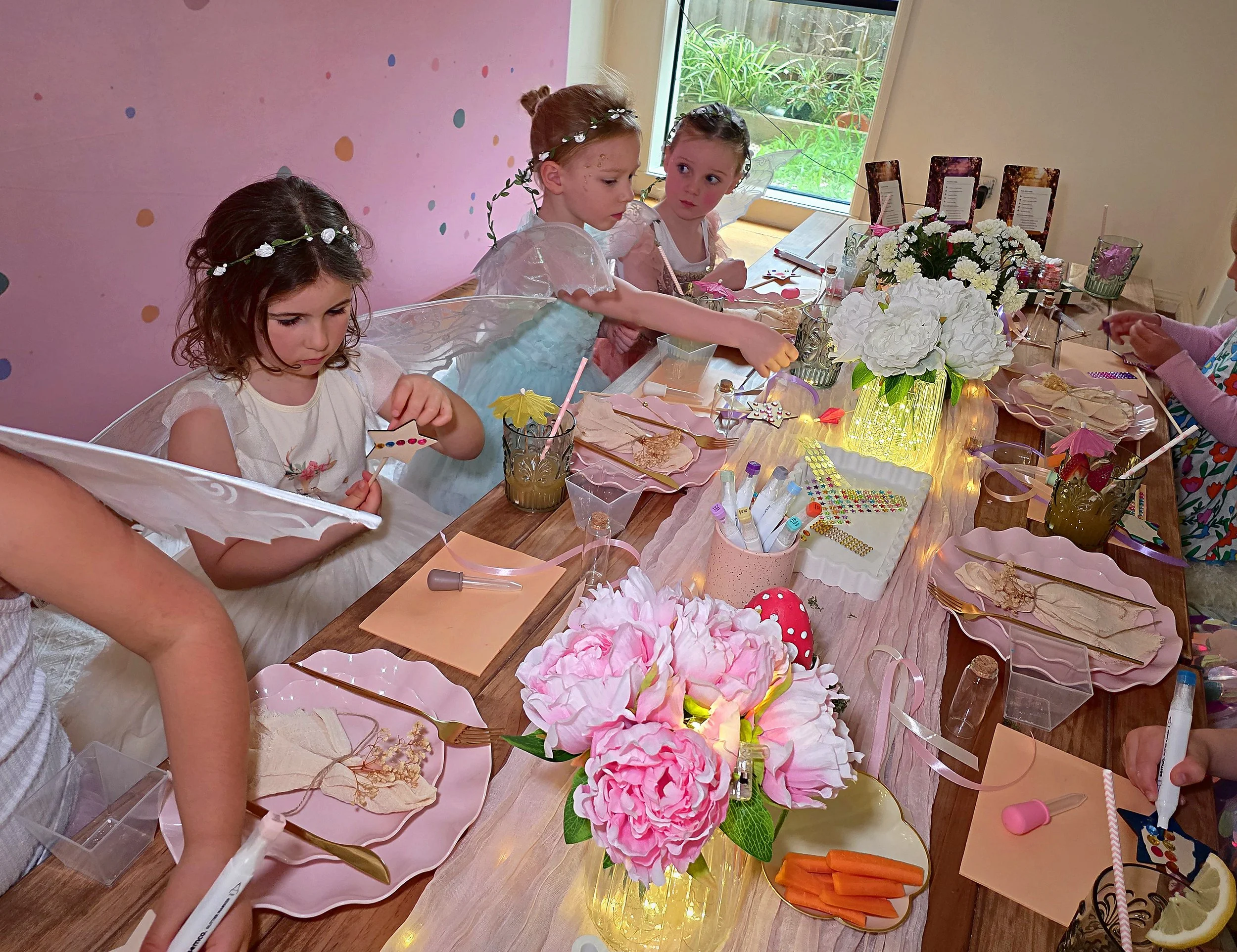 Little fairies making wands at a table with a pink peony centrepiece
