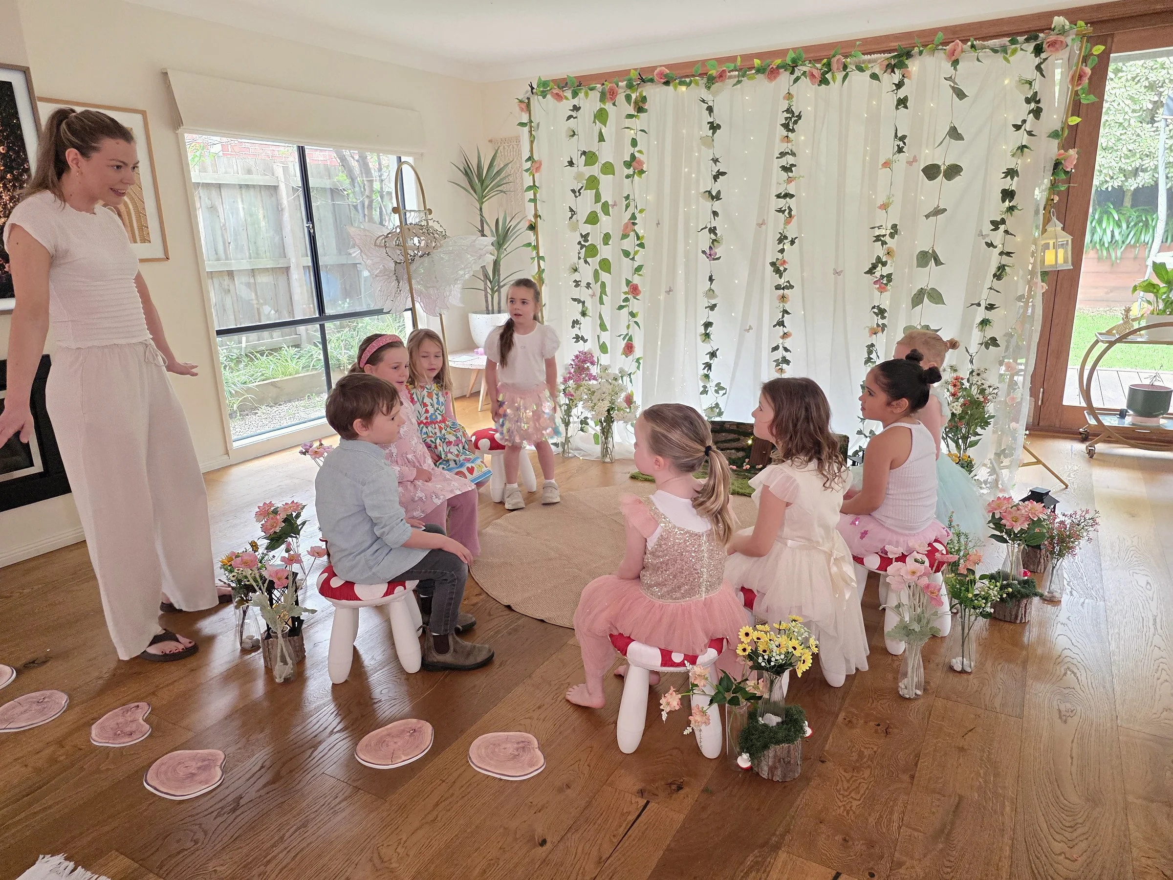 Children on toadstool stools in the fairy circle listening to the party host