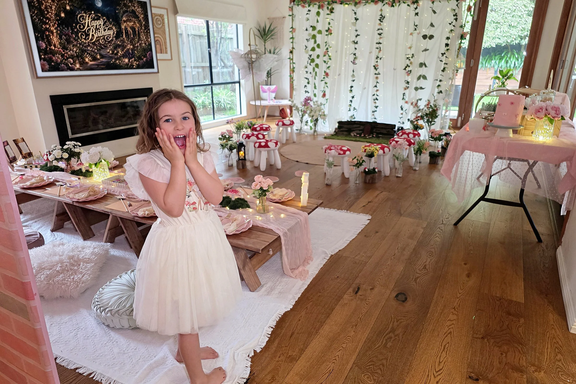 Delighted girl gasping at her first sight of an Enchanted Garden birthday party set up at home