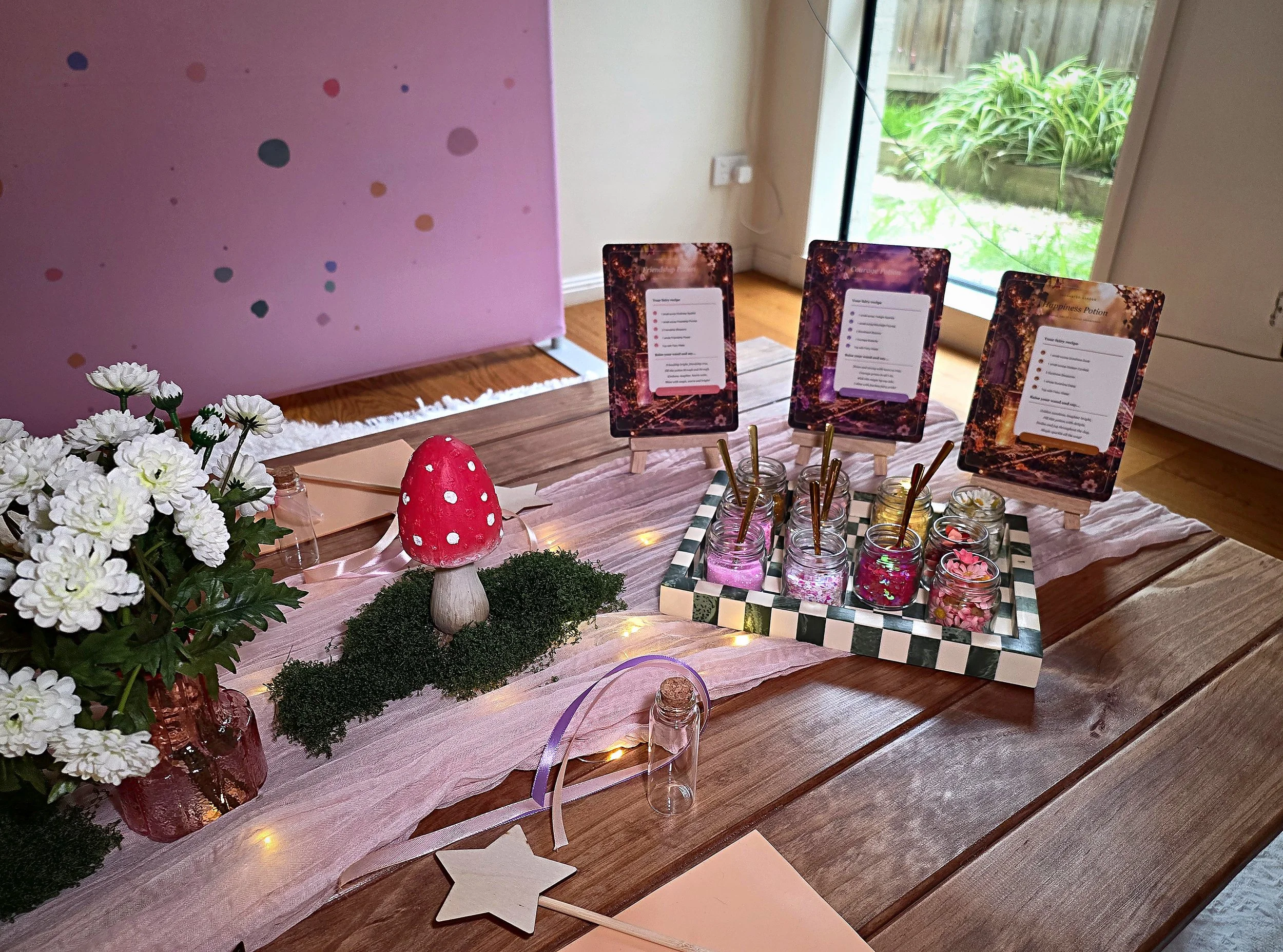 Fairy potion station with framed potion recipe cards, potion ingredients, a toadstool and moss