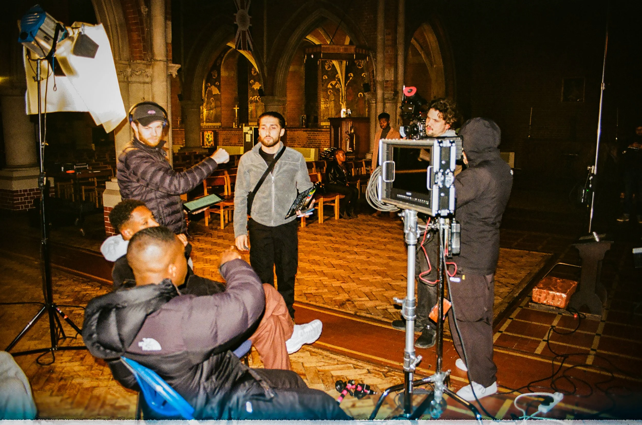 Behind the scenes the short film "Luke 6:37" inside a church, with crew members preparing equipment and framing shots.