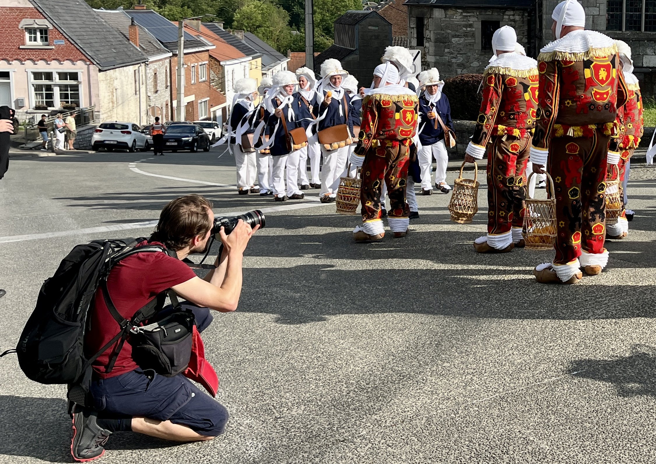 Groupe de personnes en costumes traditionnels, certains portant des paniers, lors d'une parade ou fête en plein air.