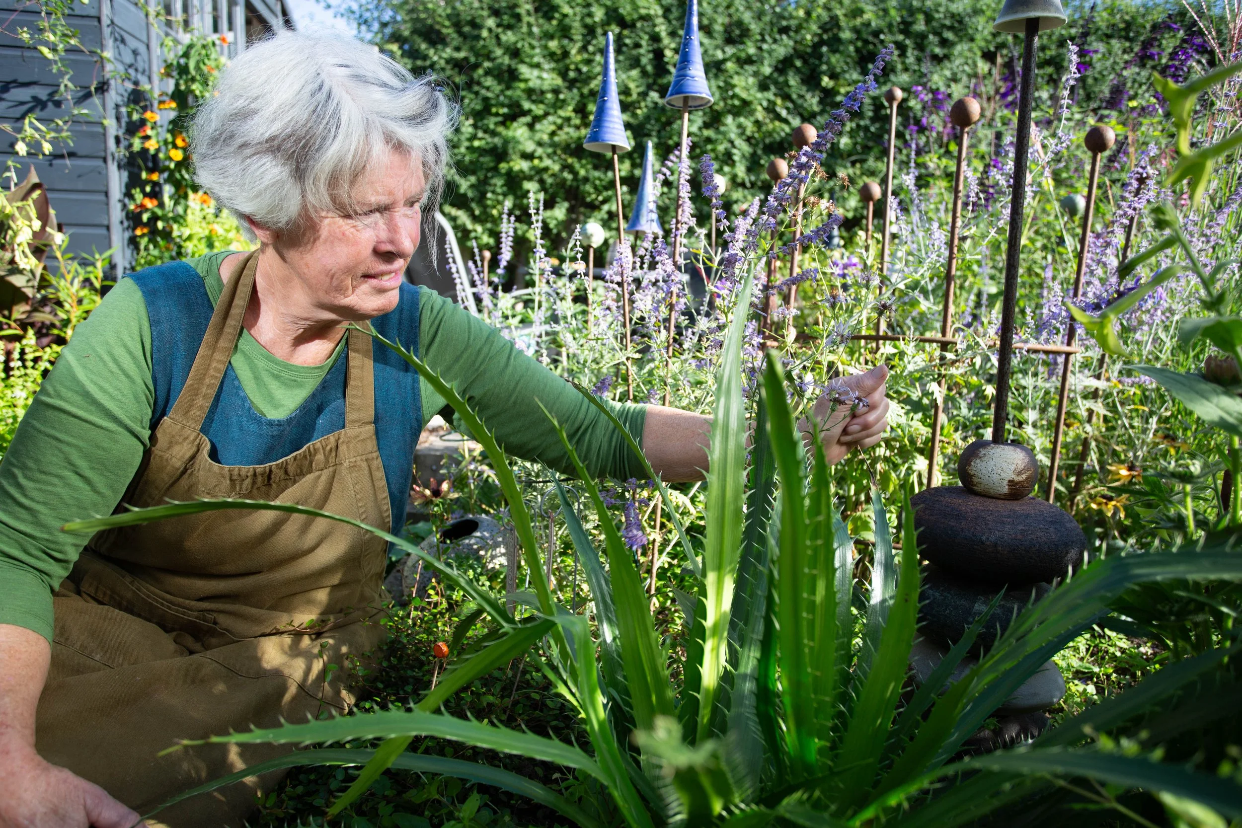 Artist Sheena Bond in her garden with her ceramics