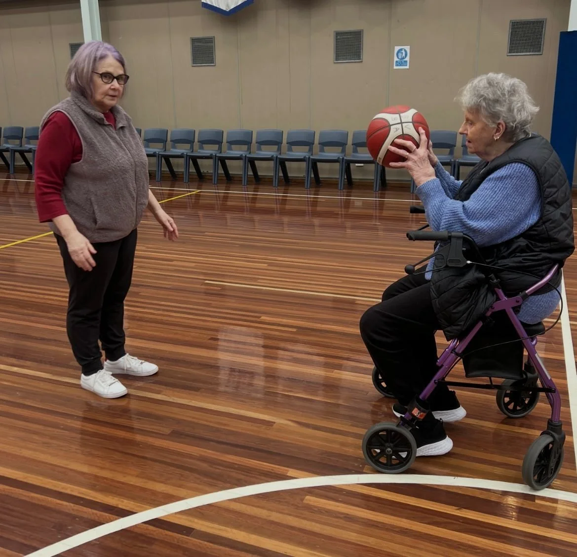 All ages walking basketball, abled player passing a ball while sitting down
