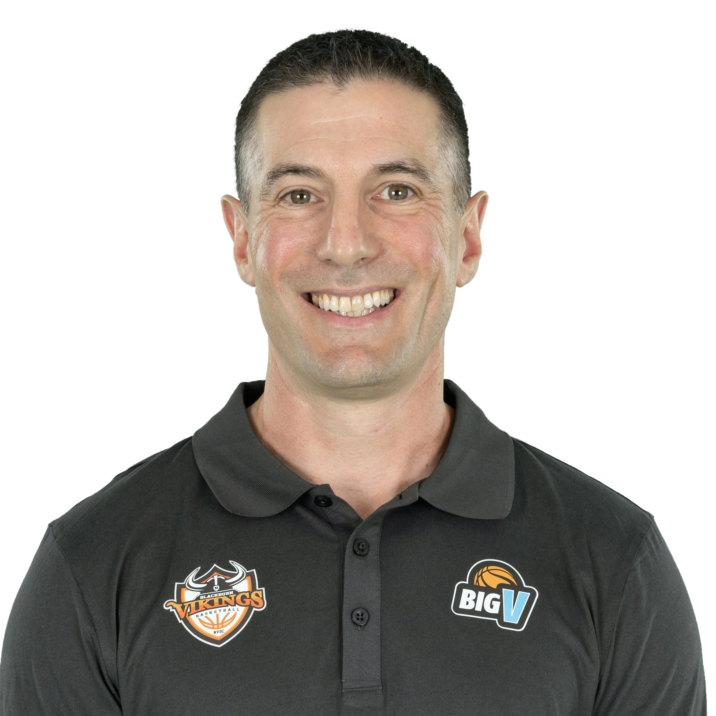 Close-up of a man's face smiling, wearing a black shirt with team logos, against a white background.