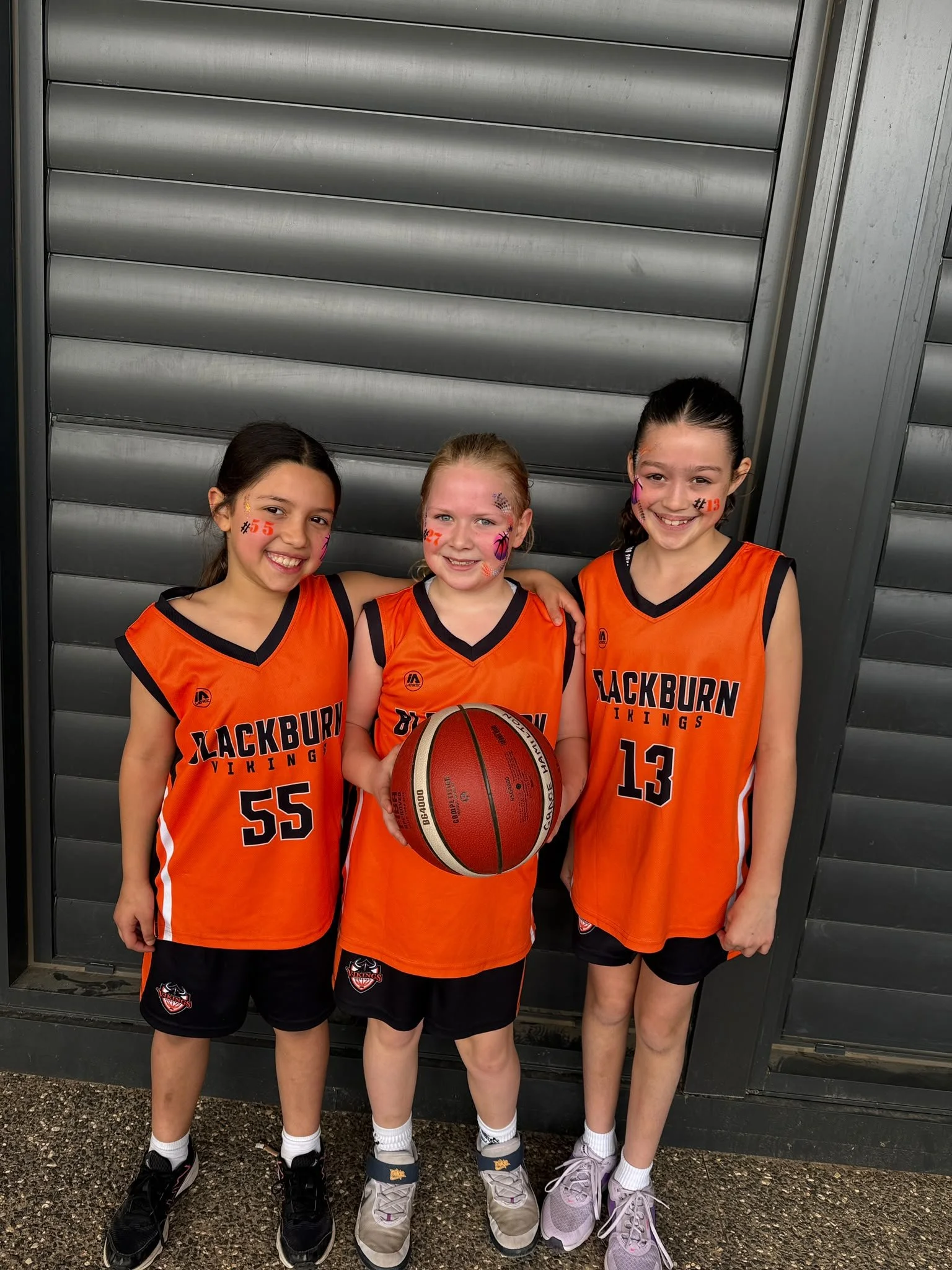 Three young basketballers smiling before a game