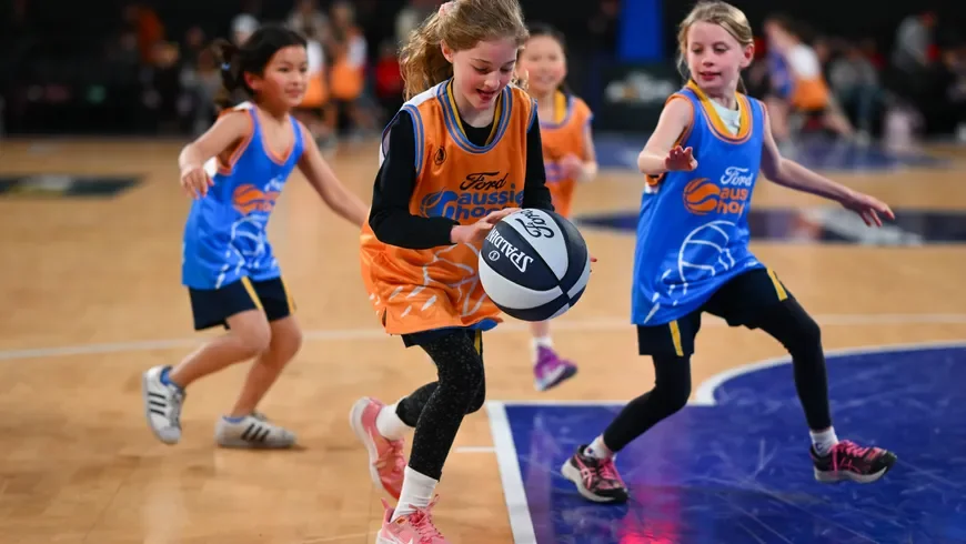 Young girls bouncing a basketball in competition