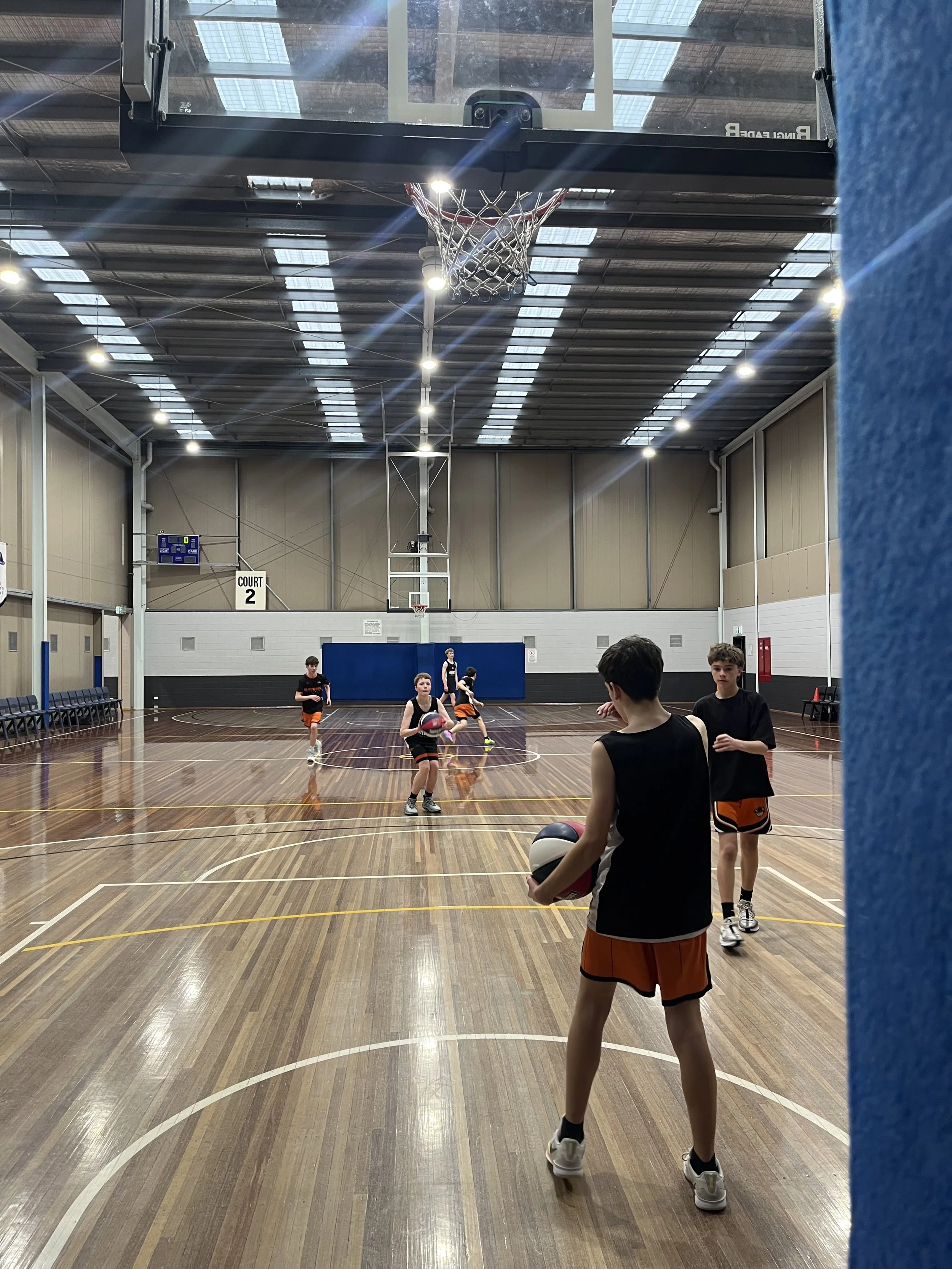 Teenage boys practicing on a full court for Domestic Academy
