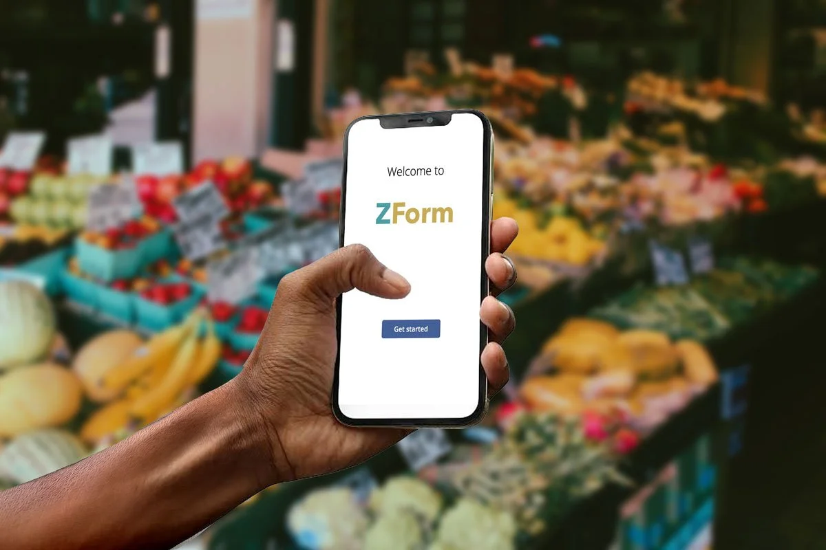 Person holding a smartphone showing the ZForm app with a grocery store produce aisle in the background.