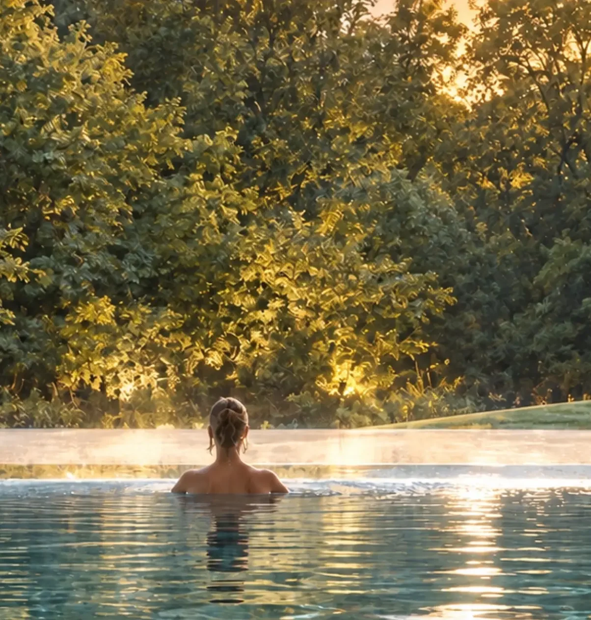 View from the residential swimming pool towards the surrounding woodland, connecting the home wellness experience with nature.