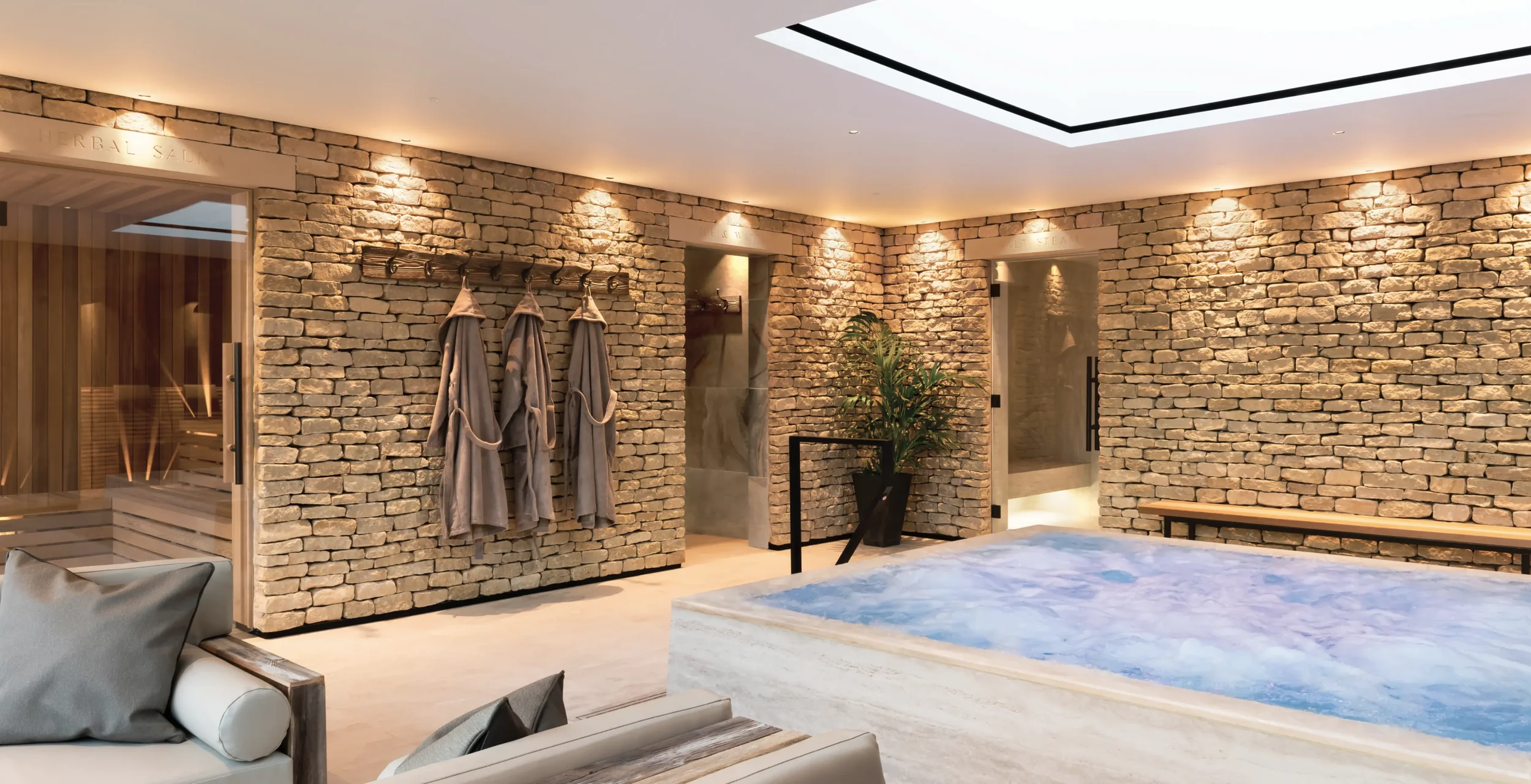 Homefield Grange Living Well Thermal Suite showing the bespoke hydrotherapy pool, drystone walling feature, and entrances into the Himalayan salt steam, herbal sauna and contract therapy room