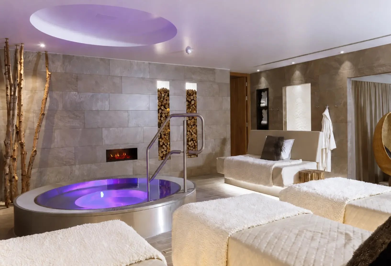 Champneys Tring relax space with hydrotherapy pool featuring warm wood accents and stone walls.