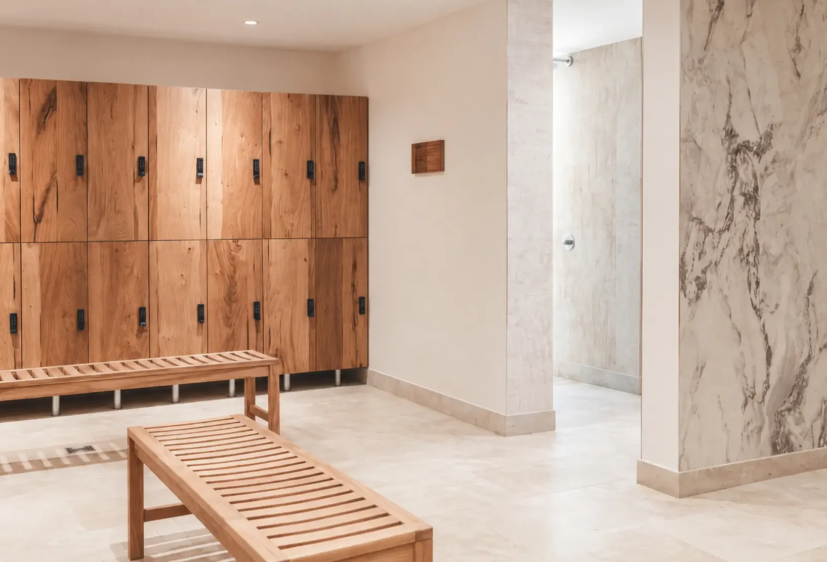Lower Mill Estate Spa changing room with bespoke timber lockers and slatted timber benches.