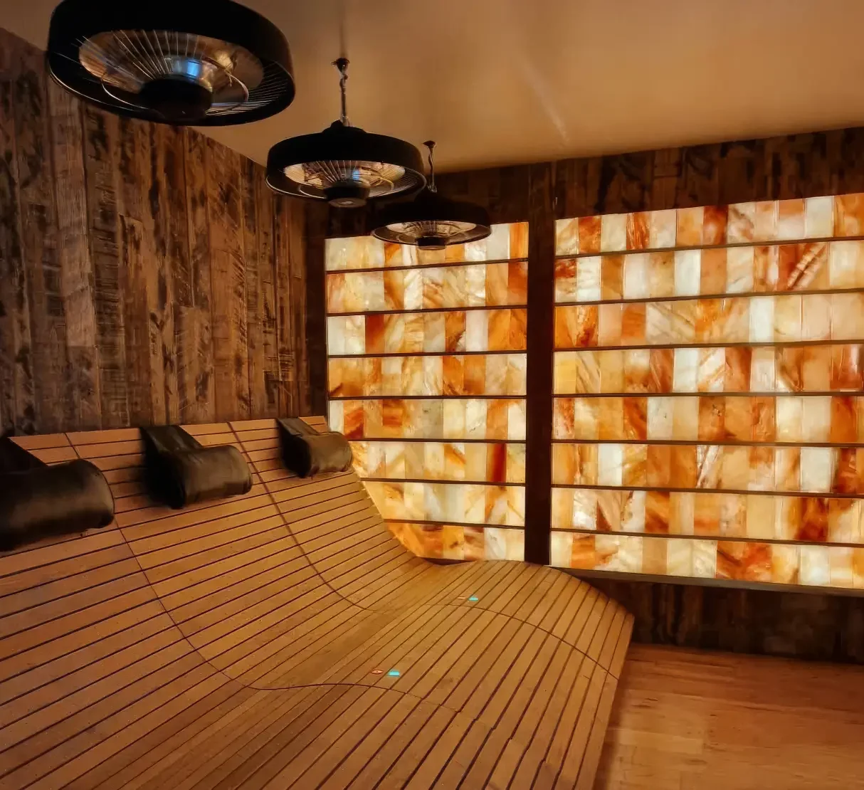 Infrared therapy bench set against a softly illuminated Himalayan salt wall within the Farmhouse Retreat wellness space.
