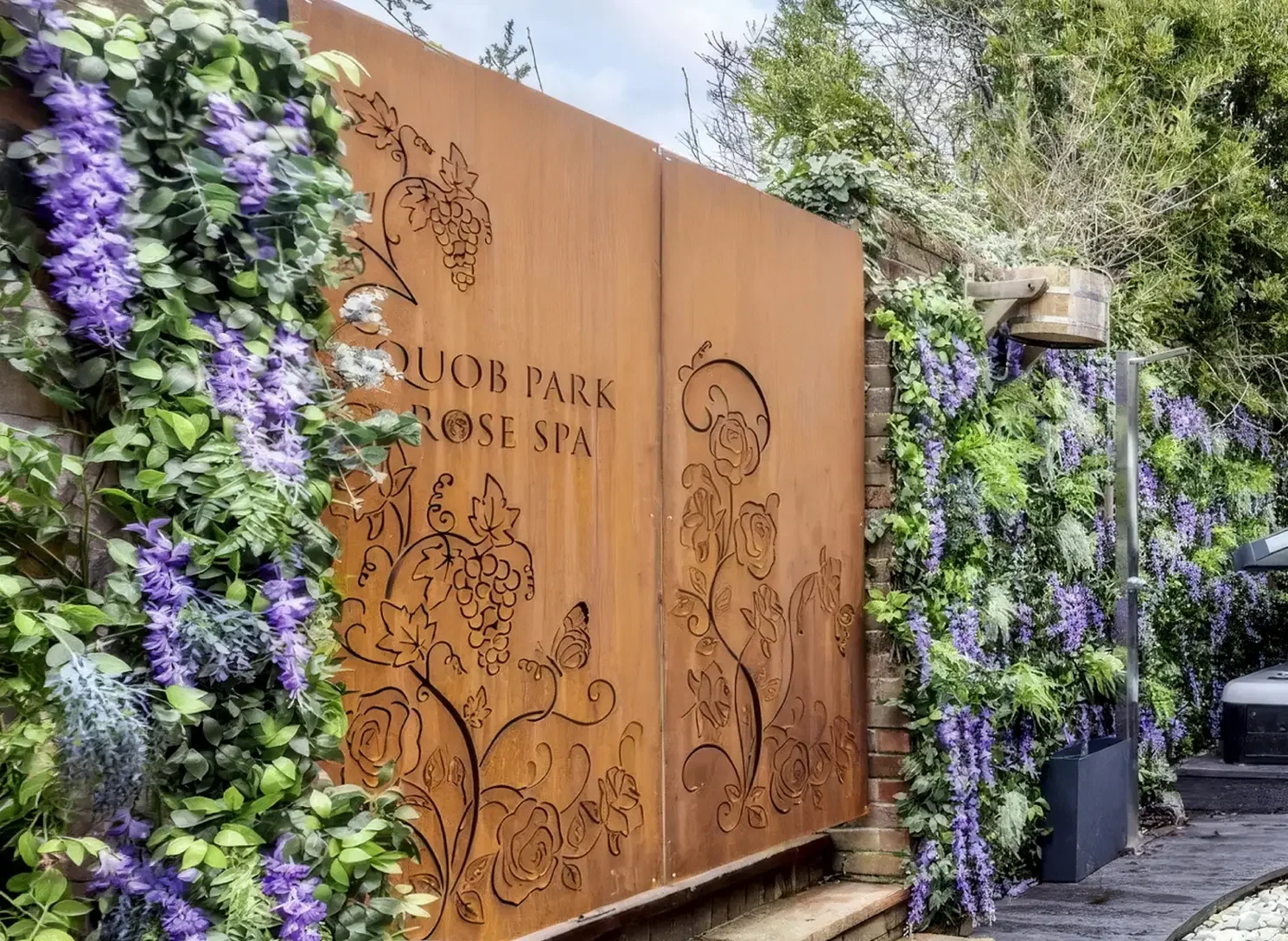 Laser-cut Corten steel spa garden entrance doors featuring the bespoke Rose Spa botanical pattern