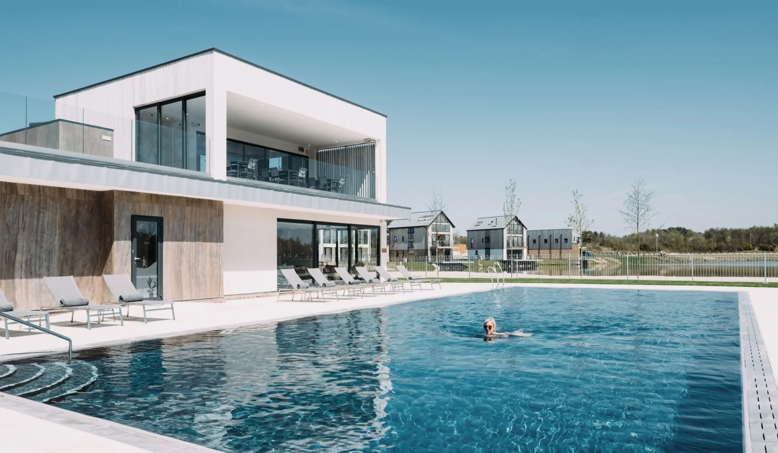 Silverlake Spa outdoor pool with the refurbished spa building and natural stone cladding inspired by the Jurassic Coast.