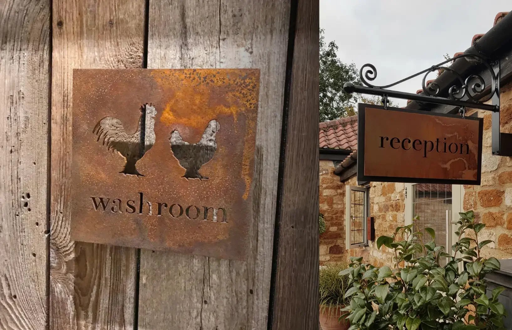 Bespoke Corten steel washroom and reception signage at Homefield Grange, bringing the retreat’s rustic farmhouse brand identity into the guest experience.
